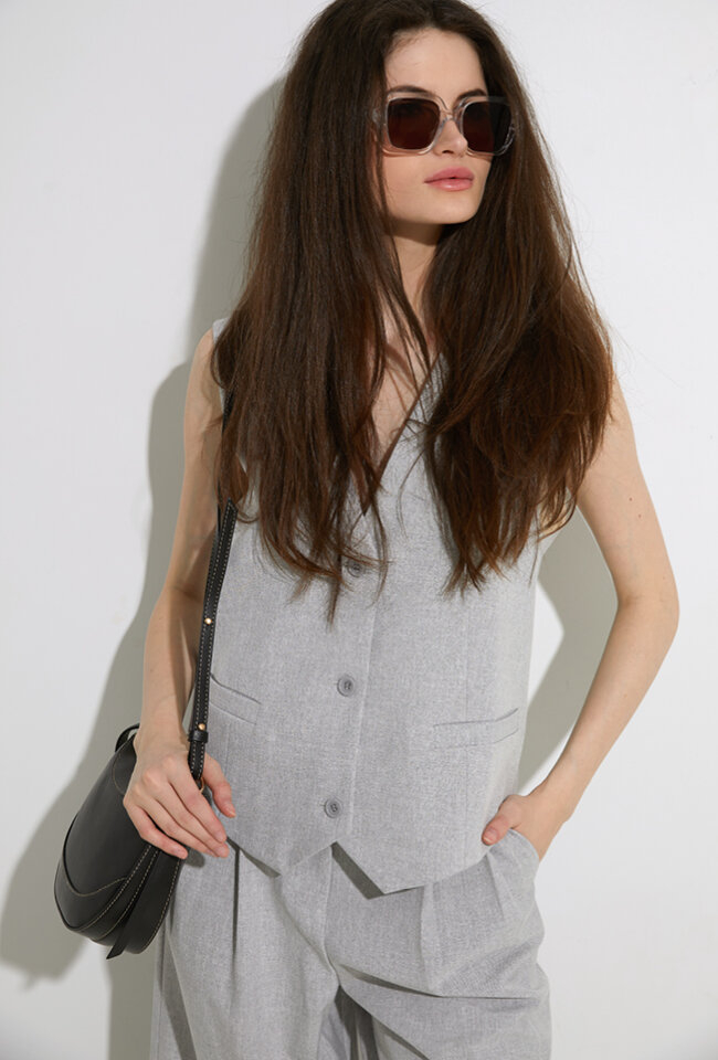 Lichtgrijze gilet met knopen en ecru detail op de achterkant Stella Nova