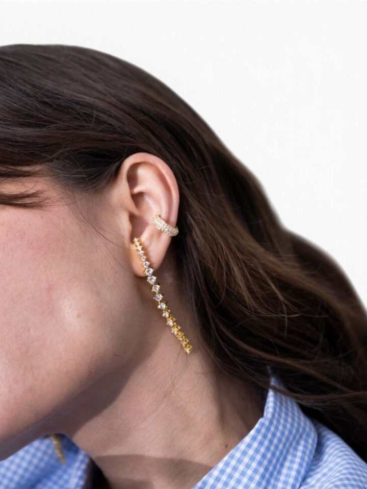 Gouden lange oorstekers met strass op het oor Ellen Beekmans